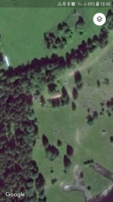 Satellitbild över en lantlig tomt med byggnader och träd i zon 5 för trädgårdsplanering.