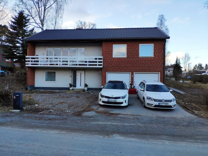 Rödtegelhus från 1968 med grusuppfart, två bilar parkerade framför garage och en obebyggd del som planeras för marksten.