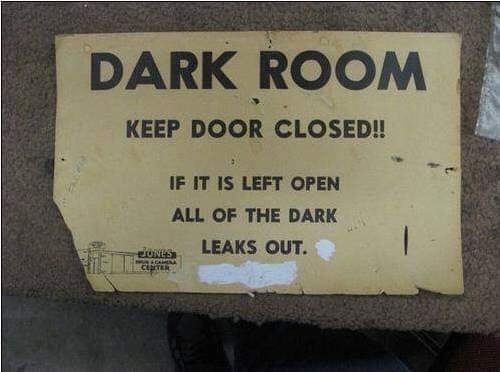 Slitet skylt med texten "DARK ROOM KEEP DOOR CLOSED!! IF IT IS LEFT OPEN ALL OF THE DARK LEAKS OUT.