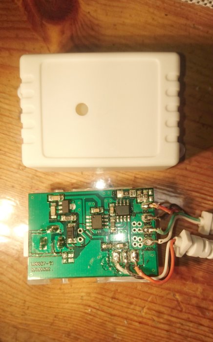 Elektronisk kontrollenhet med kretskort och lösa kabelanslutningar på en träyta.