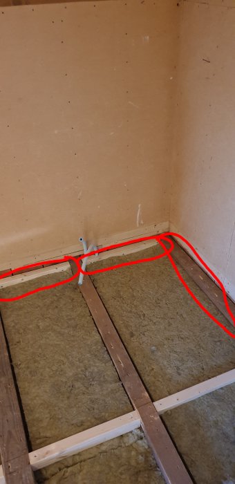 Hörn av ett rum med stenulls isolering mellan träbjälkar, markerad för ångtätning.