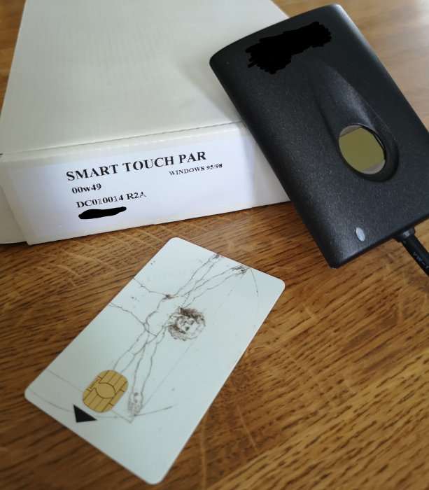 Smart Touch-kortläsare med tillhörande kort framför Smart Touch Par Windows 95/98 kartong.