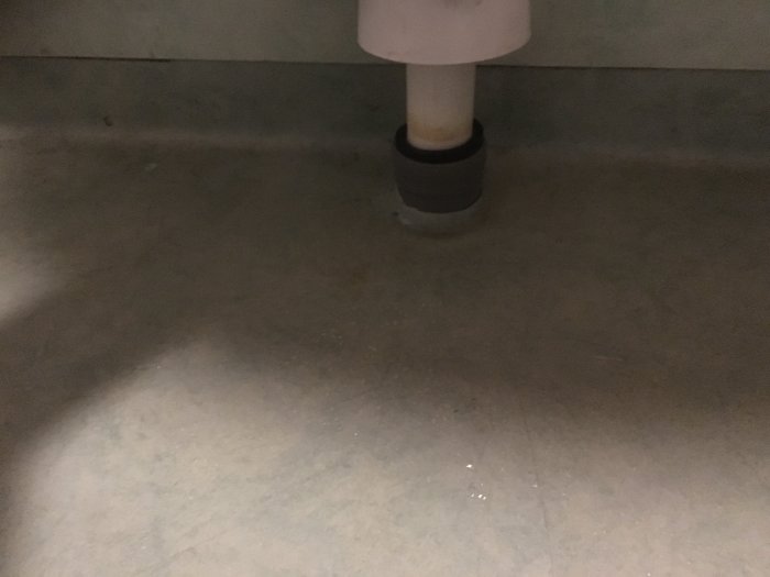 Avloppsrör med skarv synlig cirka 10cm ovanför golvet och delvis nerkopplad böj.