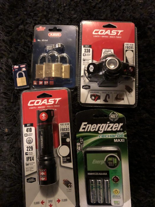 Nya produkter i förpackning inklusive Abus låspaket, Coast pannlampa och ficklampa, Energizer batteriladdare.