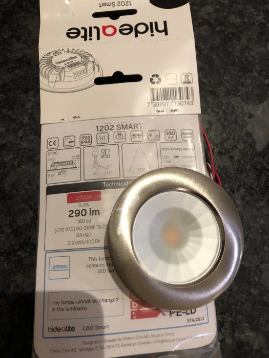 Hide a light Smart 1202 LED-spotlight med teknisk information på förpackningen, lutad mot en mörk yta.