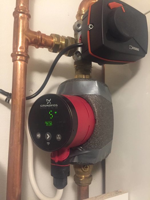 Nyinstallerad Grundfos Alpha 2 25-40 cirkulationspump och ESBE ställdon i ett värmesystem, kopplat till koppar- och plastledningar.
