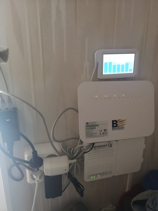 Fiberbox monterad på vägg med flera inkopplade enheter och synliga kablar runtomkring i en tvättstuga.