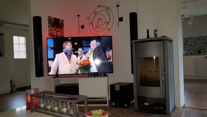 Vardagsrum med TV och kamin placerade nära varandra, kaminen påslagen utan att påverka TV:n.