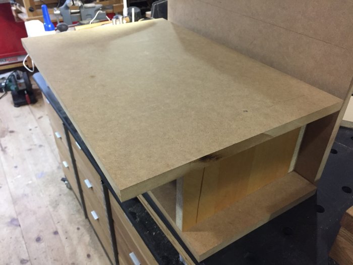 Prototyp av fräs byggd av MDF-plattor på ett arbetsbänk i en verkstad.