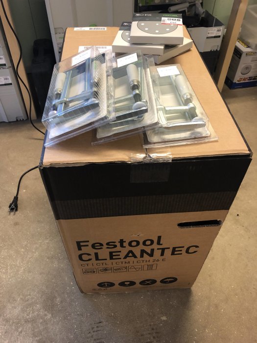 Festool-produkter på rea: CTM 26 AC dammsugare i kartong med slippapper och tillbehör på toppen.