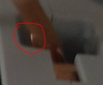Suddig bild med en röd cirkel som markerar ett glänsande objekt, misstänkt vara en felplacerad kardel.