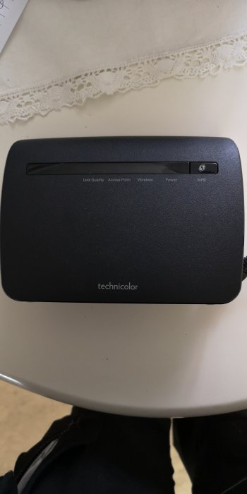 En Technicolor nätverksbrygga på bord med indikatorlampor för länkkvalitet, åtkomstpunkt, trådlöst, ström och WPS.