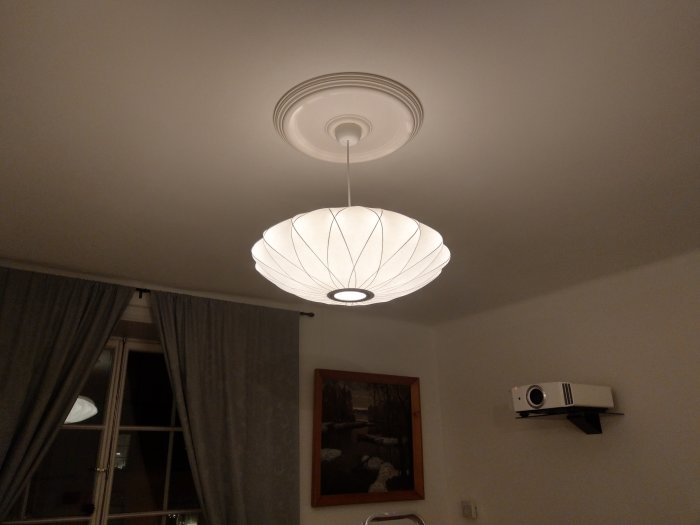 Herman Miller Saucer-pendellampa i ett rum, belyst och ersätter en naken glödlampa.