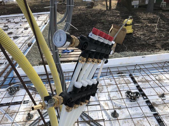 Armering och installationer för golvvärme klara för betonggjutning i byggprojekt.