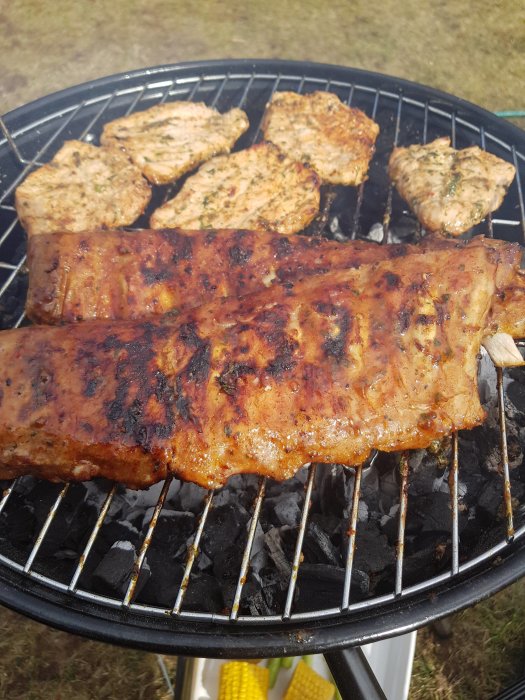 Grillat kött och majs på en kolgrill, perfekt för grillväder.