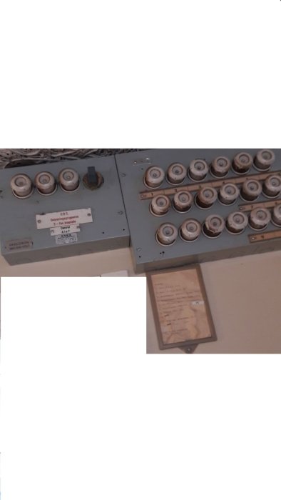 Gammal elcentral med säkringar och en lapp som anger 220V och 13A proppar för byggnaden.
