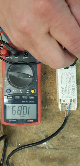 Multimeter visar 6,801 V vid mätning av LED-drivdon för hemmabygge av belysning.