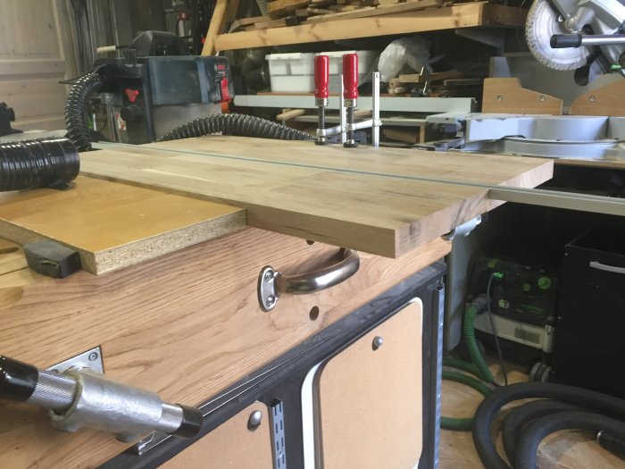 Verkstadsbild som visar hur T-spår fräses i en ekskiva, med verktyg från Makita, Bosch och Festool i användning.