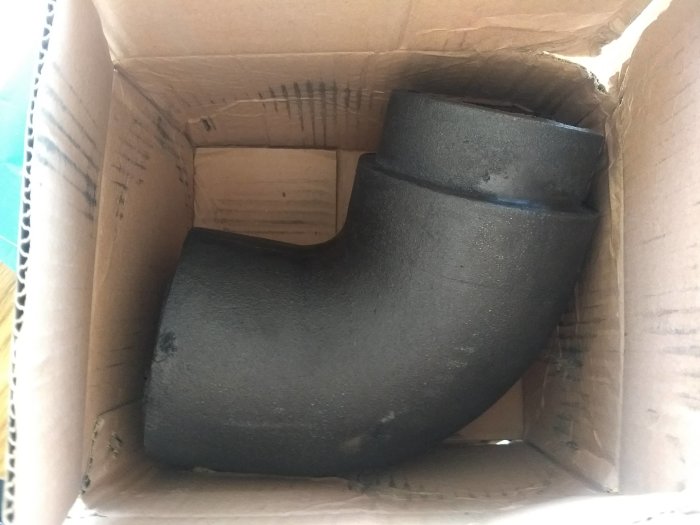 Gjutjärnsböj inuti en kartong, använd för att ansluta äldre rör med Sika Fireseal.