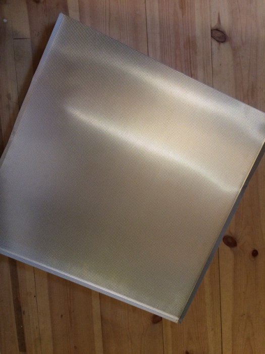Aluminiumskåpbotten som ska användas i diskbänksskåp ligger på trägolv.