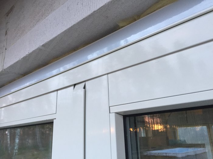 Monterat skjutparti från elitfönster med karakteristisk böjd aluminiumbeklädnad överst.