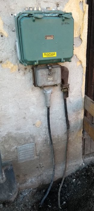 Gammal antik elektroskandialåda från 50-talet monterad på vägg med rostig strömbrytare och PVC-kabel.