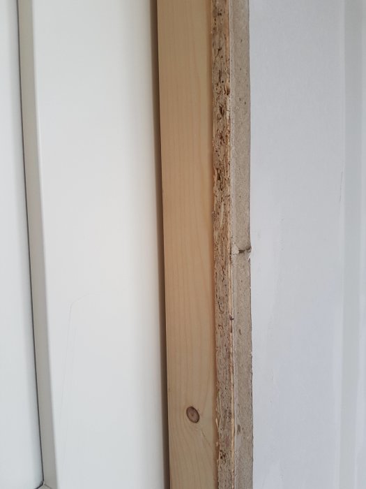 Detaljbild på ovandligt avslut mellan vägg med skjutdörr, OSB och gips, utan lister.