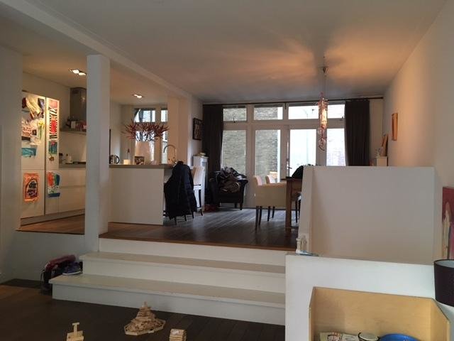 Inomhusvy av ett rum med split-level golvstrukturen där en del är upphöjd, möblerad med stolar och bord.