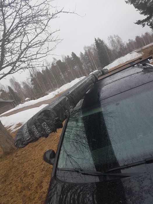 Paket med taklister på en bil i ett landskap med snörest.