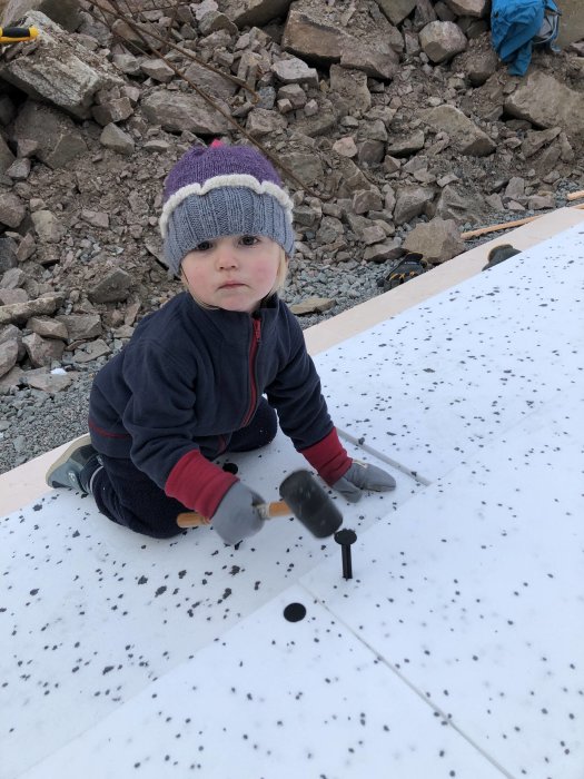 Barn hjälper till att spika cellplastspikar för isolering av vinkällare.