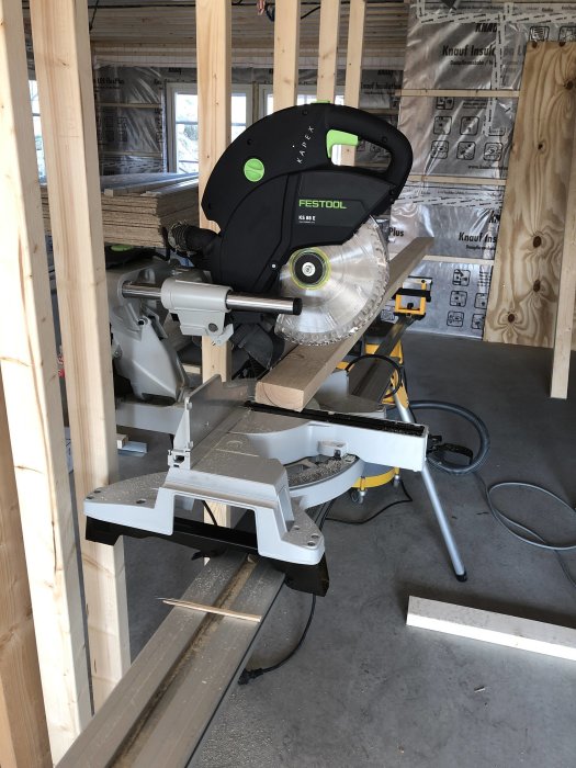 Festool Kapex geringssåg monterad på ett DeWalt sågbord i ett byggprojekt under konstruktion.