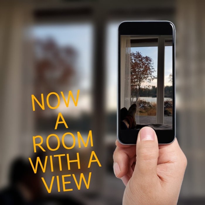 Hand håller en smartphone som visar ett skjutparti med utsikt mot en sjö, texten "NOW A ROOM WITH A VIEW" överlagd.