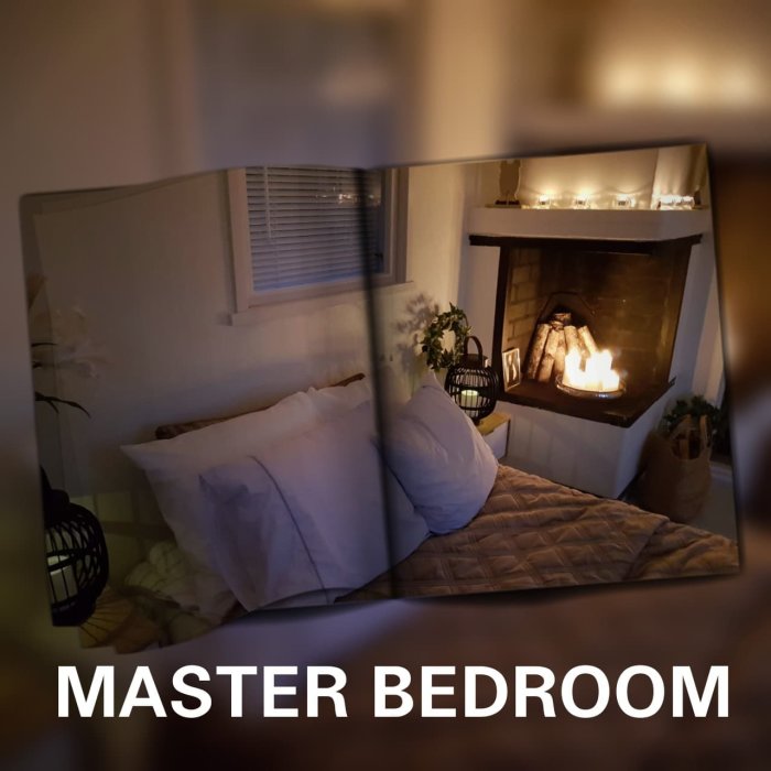 Nytt sovrum med inredd öppen spis och dekorativ belysning, säng med vita kuddar och text "MASTER BEDROOM".