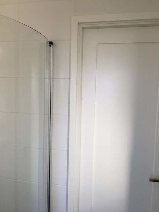 Dörrkarm med plastklackfoder intill en dusch med kakelvägg i ett våtutrymme.