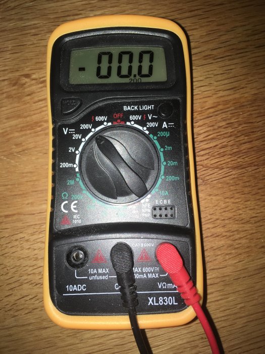 Multimeter visar 0.00V, inställd på 200V, med röd och svart testledning ansluten.