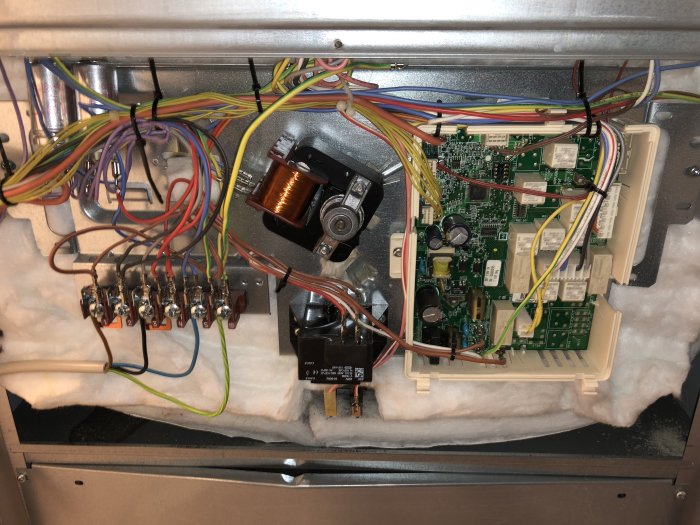 Inre av en enhet med elektroniska kretsar, kablar och komponenter, eventuellt sökande efter överhettningsskydd.