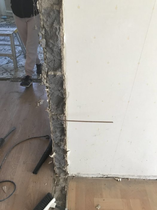 Ojämn blåbetongvägg och gipsvägg som möts efter rivning, behöver utjämning.