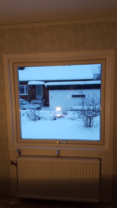 Öppet vipp-fönster med utsikt över snötäckt trädgård och hus, märkt "FIX Made in Sweden".