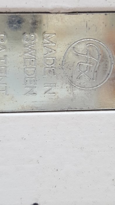 Stämpel med texten "MADE IN SWEDEN" och logotypen FIX på ett vitt fönster.