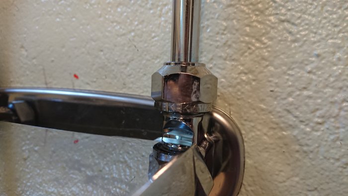 Rördel med mutter och reflexion av vatten ser misvisande ut, inget läckage efter åtdragning.