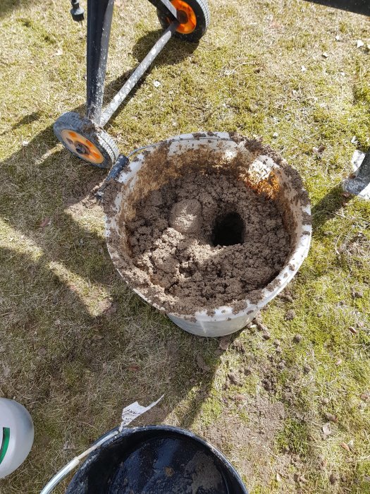 Hink med hemgjord lerklining bestående av lera, sand och torvspånsblandning för användning i renoveringsprojekt.