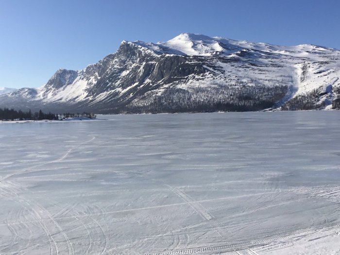 Vinterlandskap med fruset vatten och berg, svårt att nå för elektriker på påskafton.