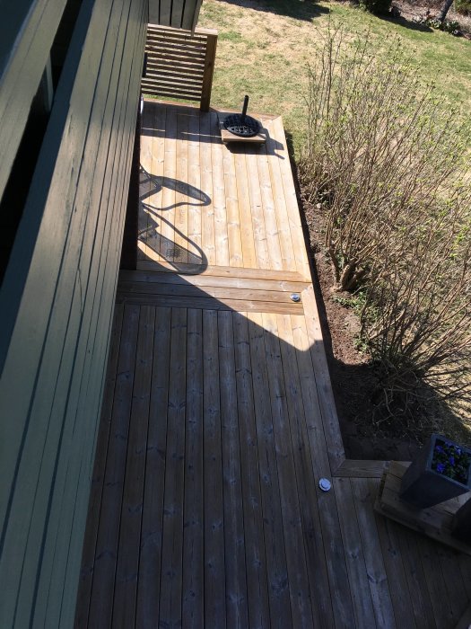 Högtryckstvättad och obehandlad veranda på ca 50 kvadratmeter med trädgårdsdetaljer.