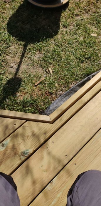 Träbrädor på gräs med korrekt sågad vinkel, redo för att kapas till projekt.