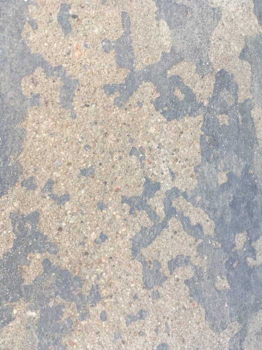 Slitet trappsteg med flagnande målfärg i olika nyanser av grått och beige.