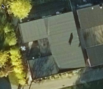 Luftvy av ett enplanshus med U-formad layout och ett altantak över en del av innergården.