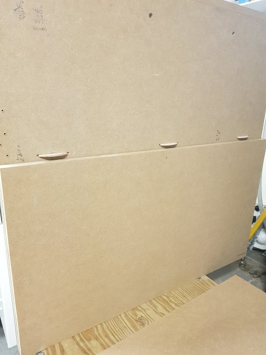 Pågående byggprojekt med uppmätta MDF-skivor och markeringar för kapsning.