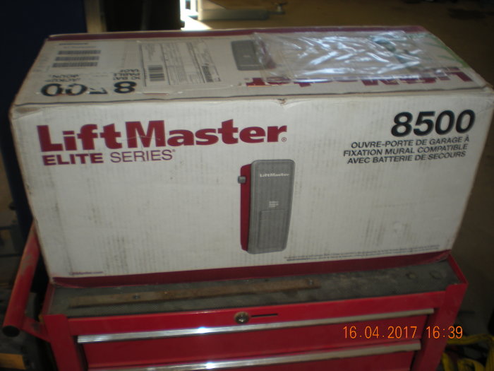 LiftMaster garageportöppnare i förpackning på arbetsbänk med datumstämpel.