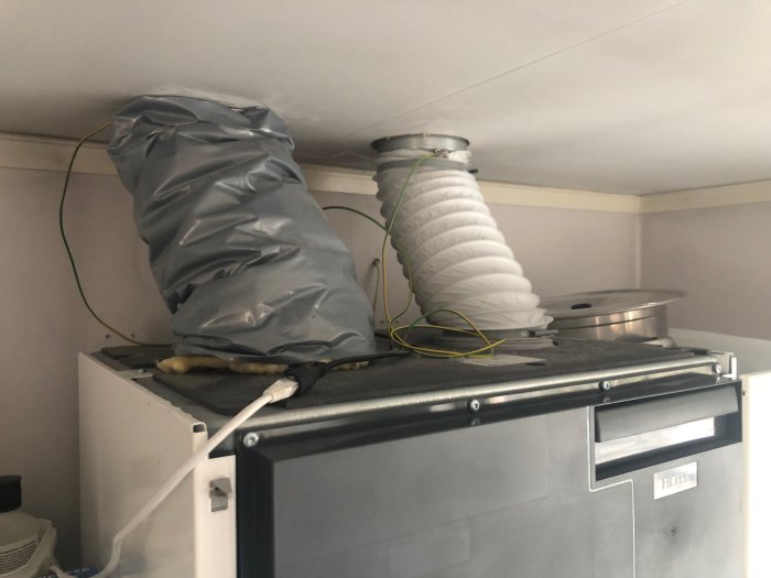 Ventilationsenhet med anslutna flexkanaler och tejpade rör på ovansidan.