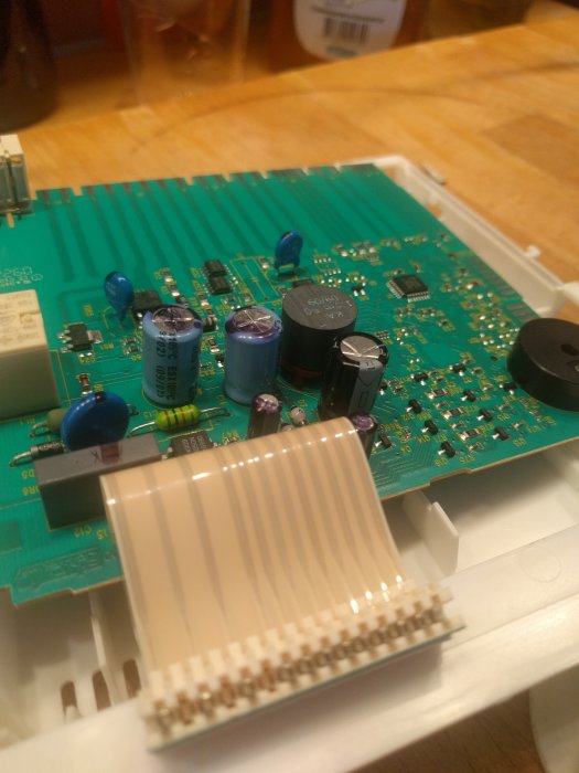 Elektronikkort med kondensatorer och kretsar, en ersatt med 220uF 63V kondensator i en hemmiljö.